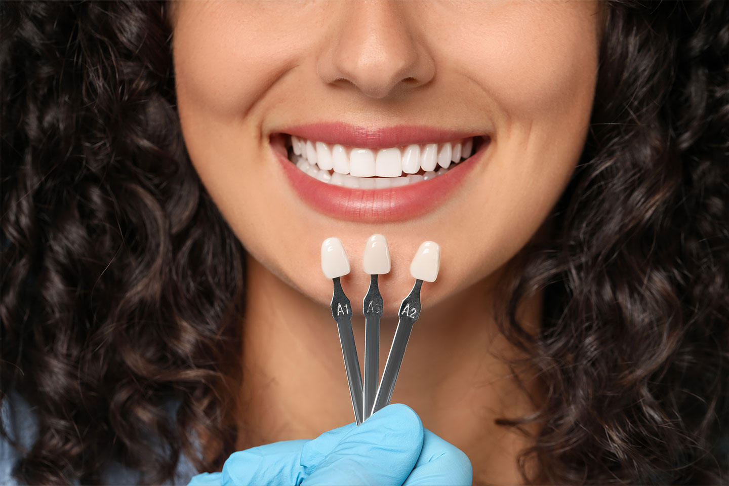 A woman showing off her teeth after dental veneers treatment