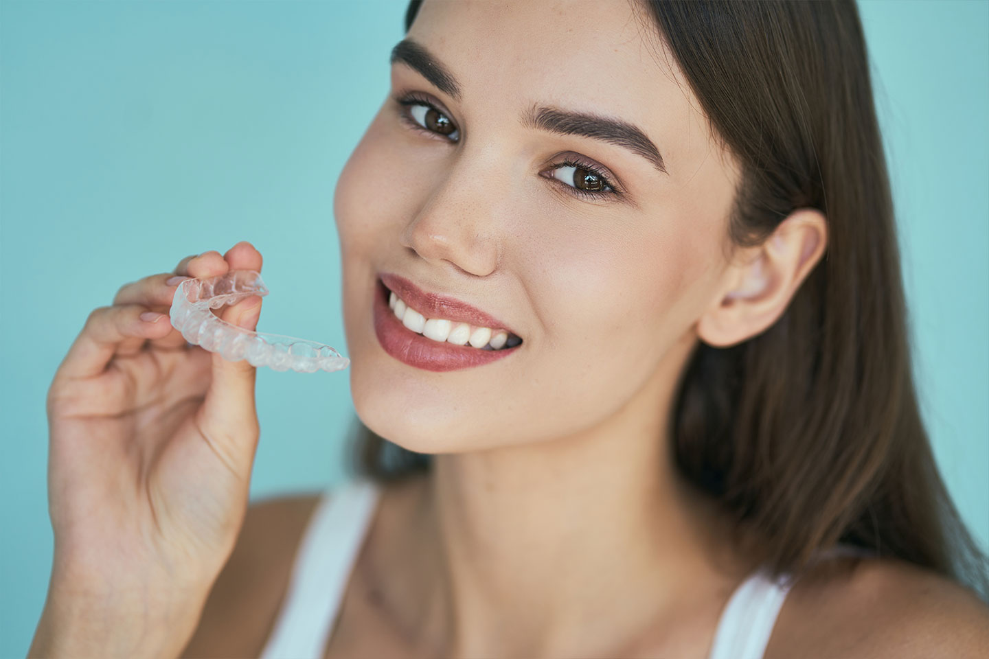 A woman holding Invisalign for their orthodontic treatment